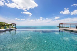 Una piscina a sfioro cristallina con vista sull'oceano e sul cielo.