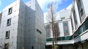 A modern building with a geometric facade, multiple windows, and a clear sky.
