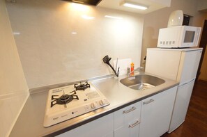 Appartement supérieur (701) | Cuisine privée | Réfrigérateur, four à micro-ondes, surface de cuisson