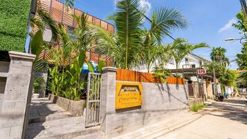 A building with a sign indicating a spa, surrounded by palm trees and a staircase leading to the entrance.