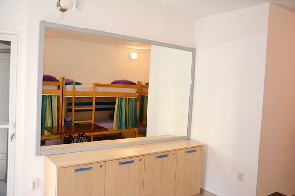 A dormitory room with bunk beds, a mirror, and a wooden cabinet. - Montenegro Backpackers Home Budva (Budva)