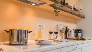A kitchen with a pot of spaghetti, wine glasses, and various kitchen items on the counter. - Pool, grill, WiFi, bicycles, billiards, dishwasher, washing machine (Loborika)