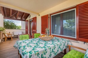 A covered outdoor seating area with a table, chairs, and a fruit basket. - Pool, grill, WiFi, bicycles, billiards, dishwasher, washing machine (Loborika)