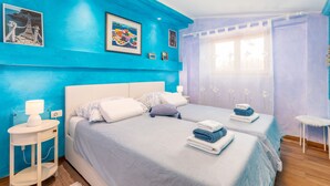 A bedroom with two beds, a nightstand, a window with curtains, and artwork on the walls. - Pool, grill, WiFi, bicycles, billiards, dishwasher, washing machine (Loborika)
