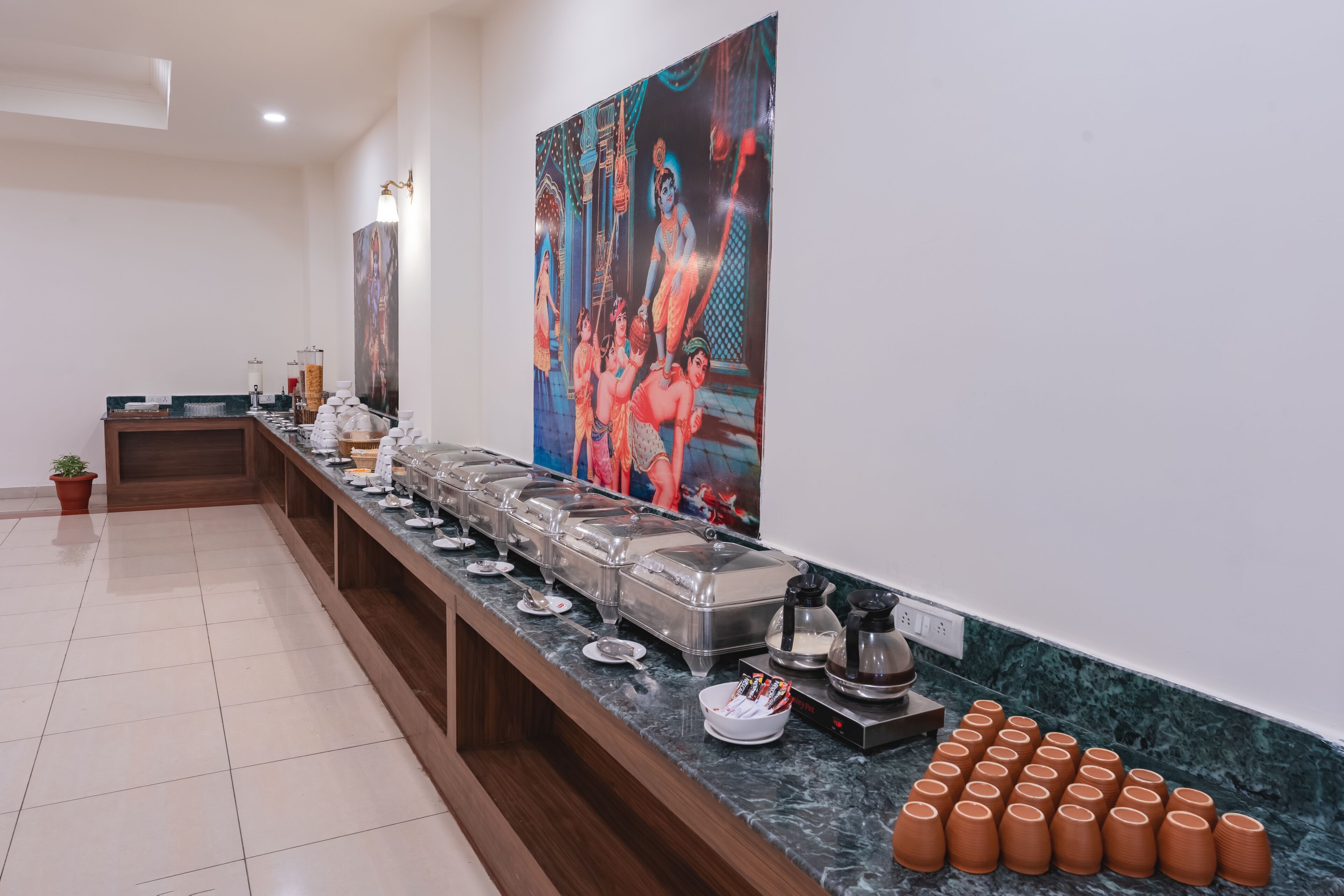 A buffet area with a marble counter, multiple food containers, and a large painting on the wall.