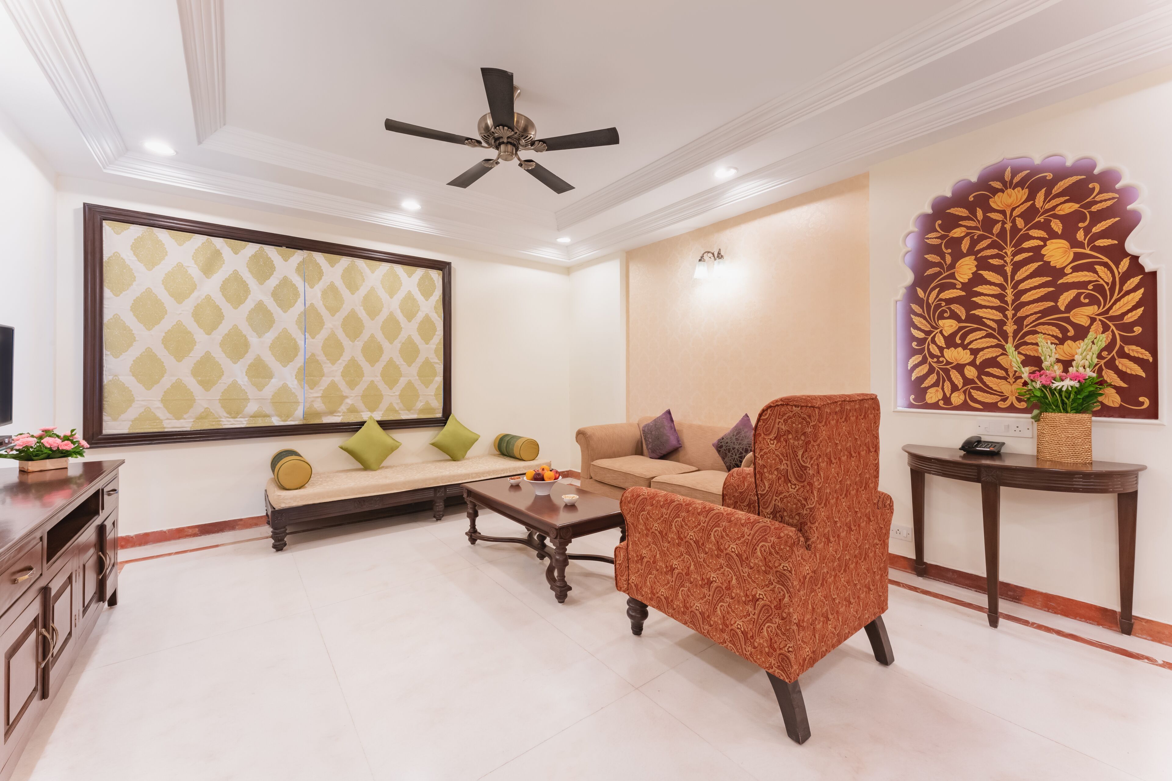 A living room with a sofa, armchair, coffee table, and decorative wall art.