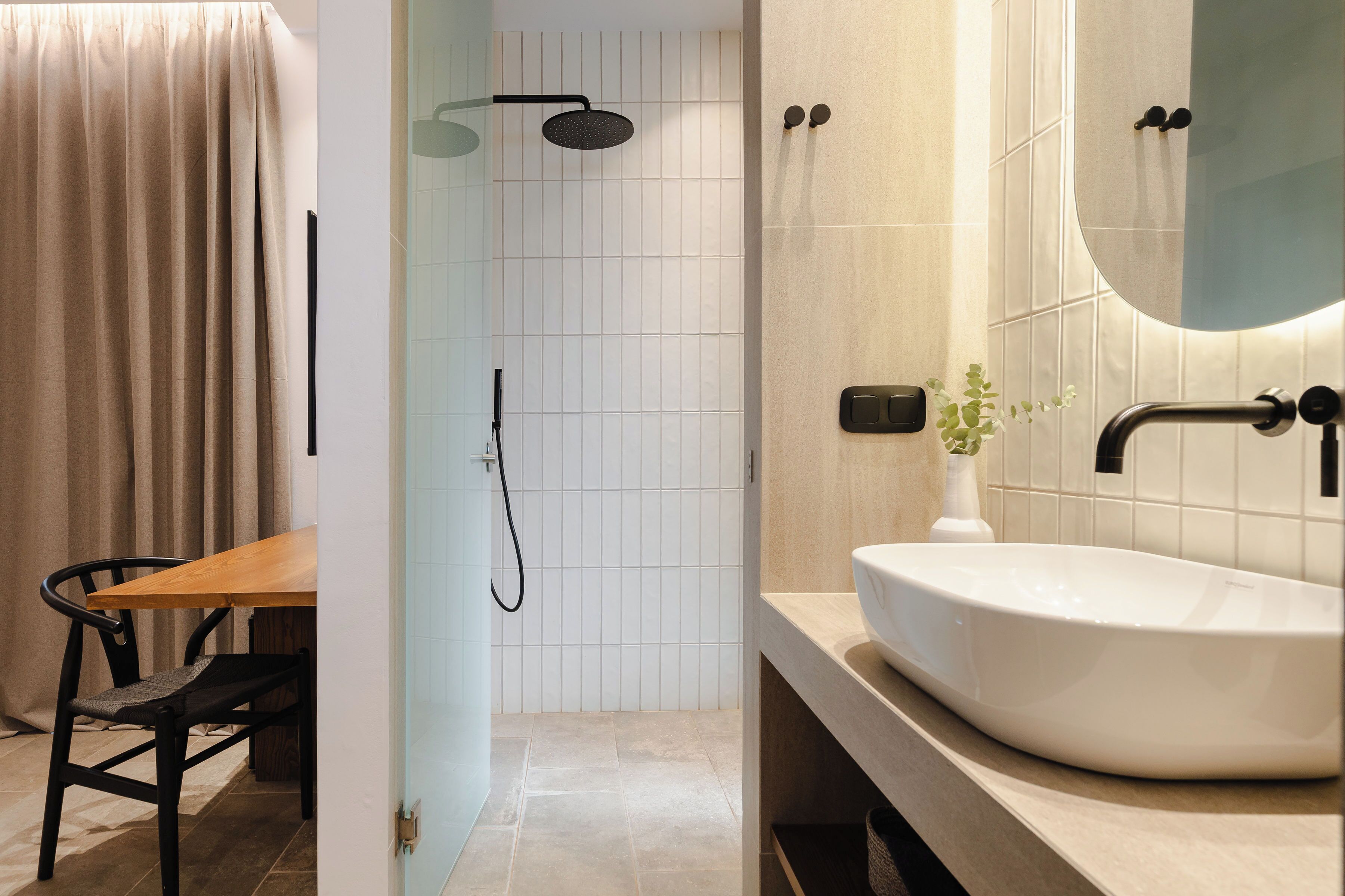 A modern bathroom with a shower, a sink, and a mirror.