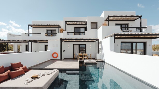 Een modern meerlaags huis met een zwembad op het dak, buitenmeubels en een terras.