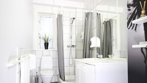 Un baño moderno con inodoro, ducha y lavamanos.