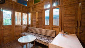 Un intérieur en bois avec un banc, une table ronde et un meuble.