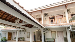 Un bâtiment traditionnel doté d’un toit en tuiles, d’un balcon et d’un escalier menant à un étage supérieur.