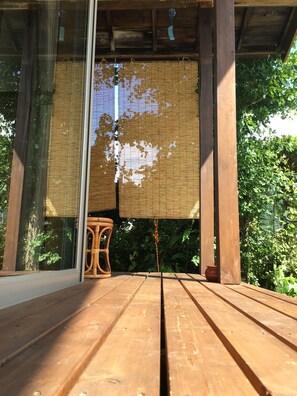 A wooden deck with a bamboo screen and a wicker chair. - Cottage TOGAWA (Fujikawaguchiko)