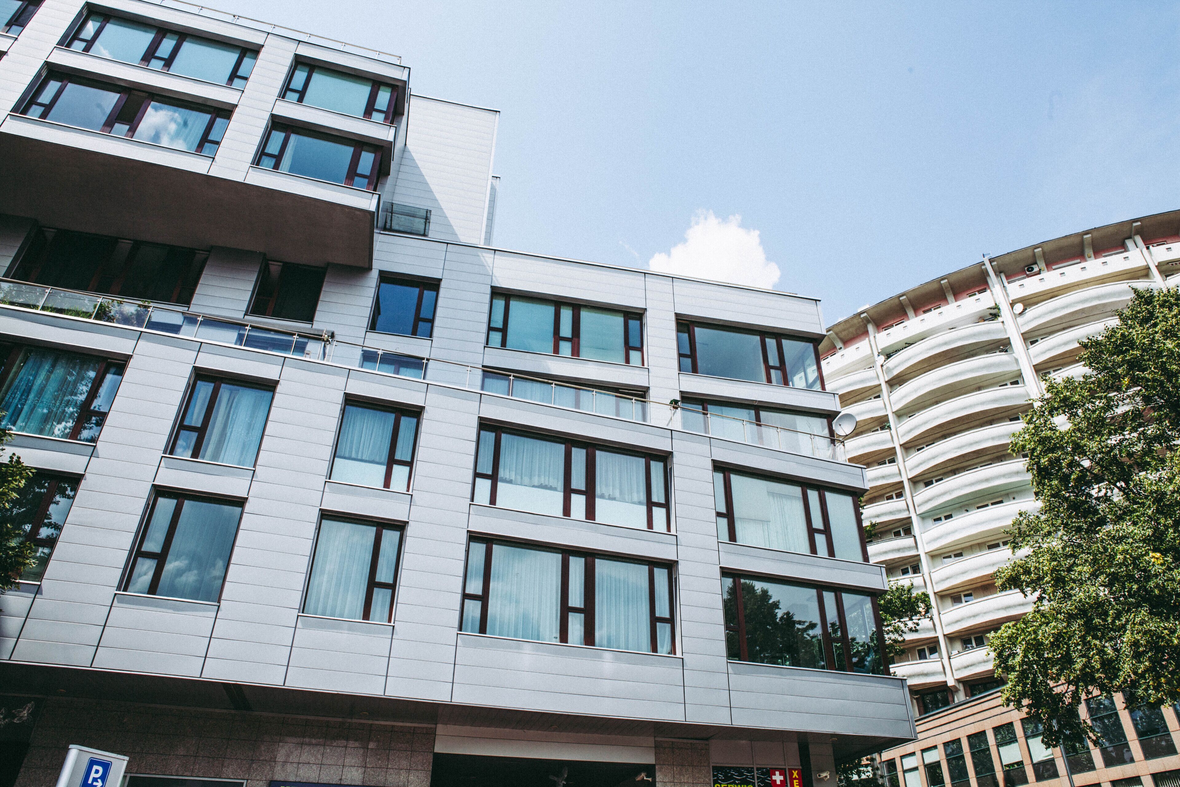 Un immeuble moderne à plusieurs étages, doté de grandes fenêtres et de balcons.
