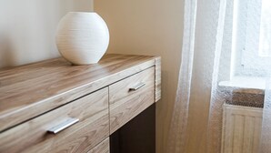 A wooden desk with a white vase, a drawer, and a window with sheer curtains. - Modern Apartment (Warsaw)