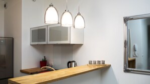 A modern kitchen with a wooden countertop, stainless steel appliances, and pendant lighting. - Silver Apartments - ul. Klopot (Warsaw)