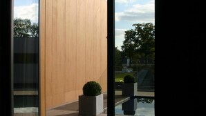 Une pièce dotée d’une grande porte-fenêtre coulissante donnant sur une terrasse extérieure.