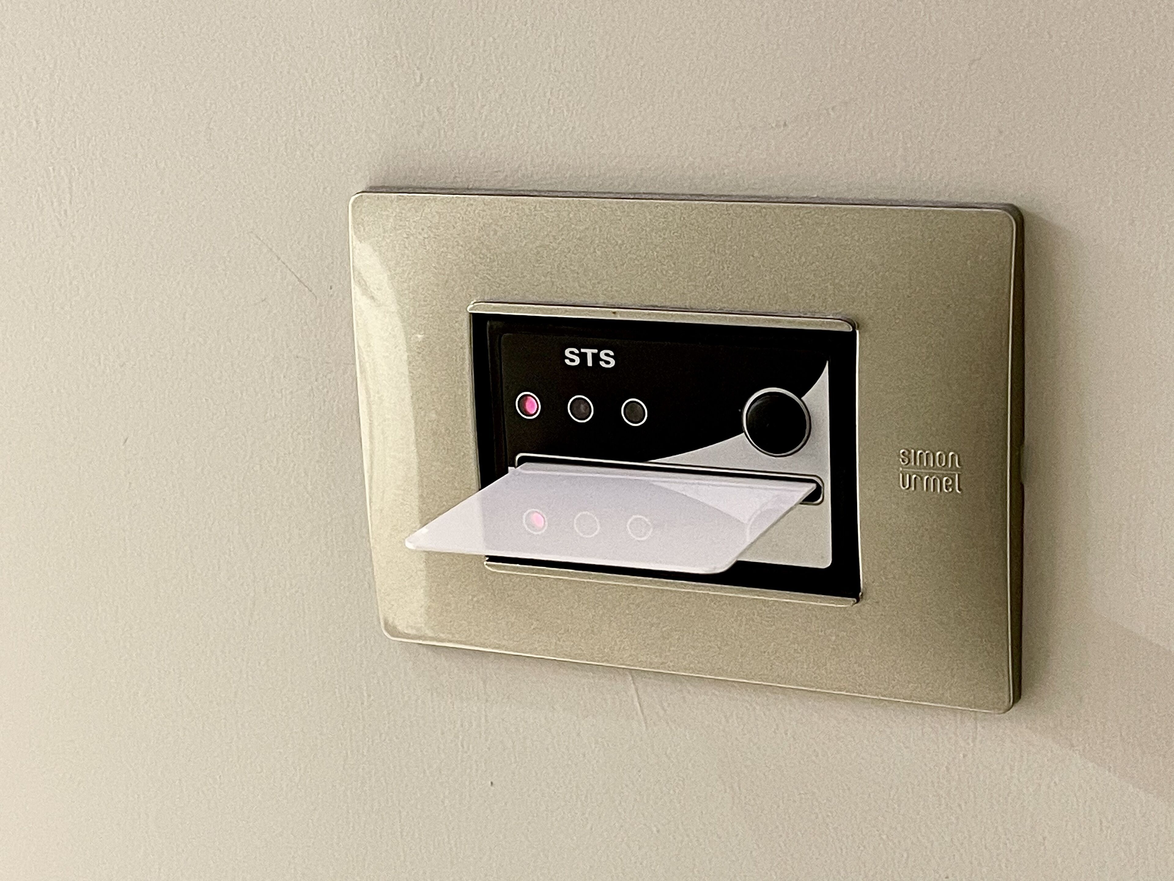 A thermostat with a digital display and control buttons, mounted on a wall.