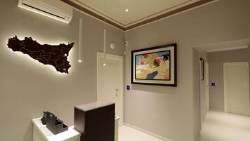 A hallway with a map, a framed painting, and a reception desk.