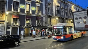 Una calle con un edificio que tiene varios balcones y un restaurante.