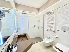 Habitación cuádruple Deluxe, varias camas, vista a la ciudad | Baño | Regadera, regadera tipo lluvia, amenidades de baño gratuitas 