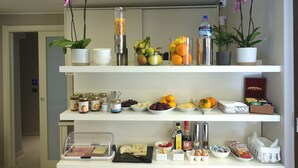 Una cocina con estantes llenos de frutas, verduras, condimentos y diversos utensilios.