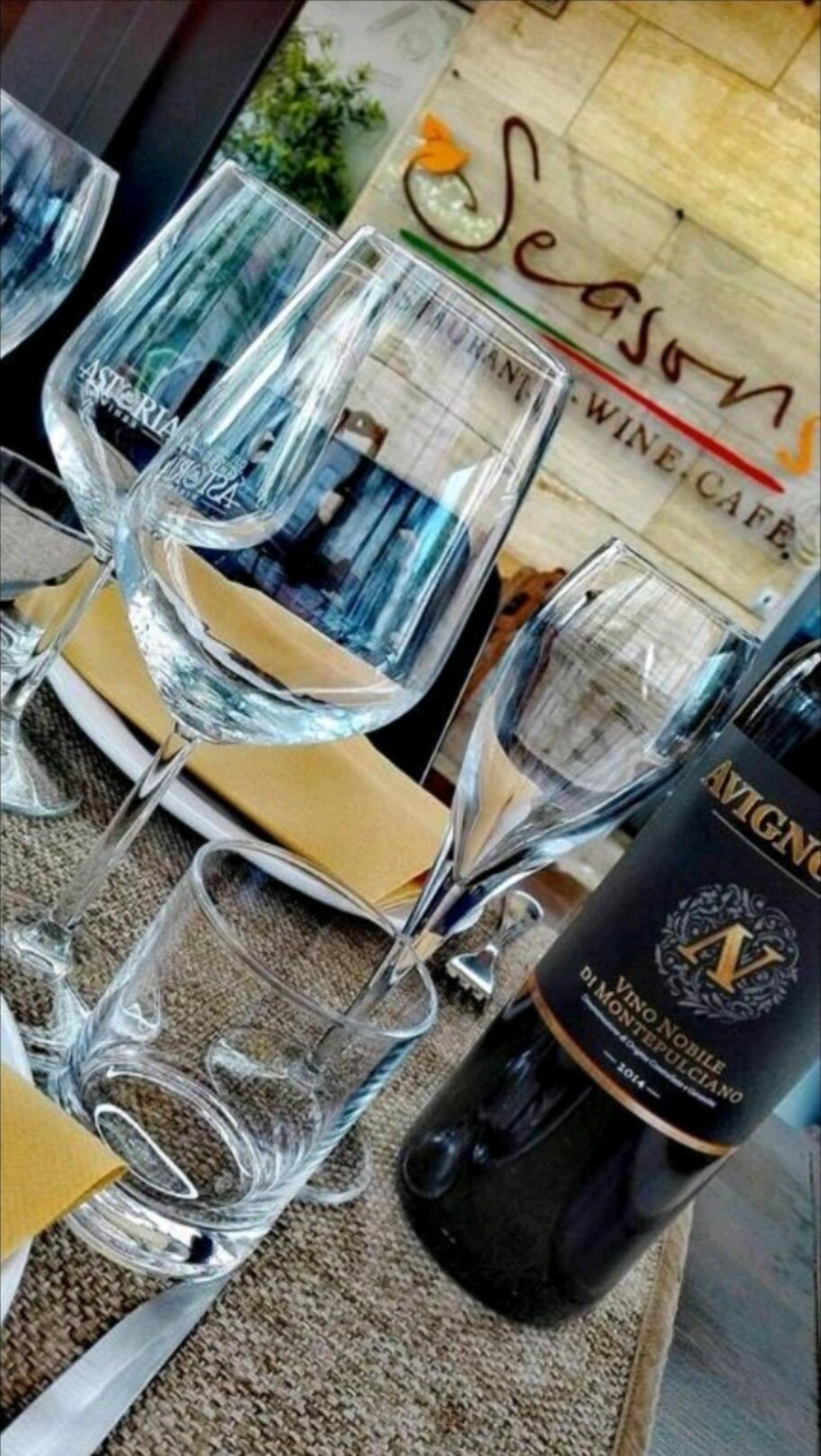 A table with empty wine glasses and a bottle of wine.