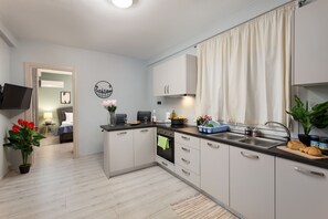 Deluxe-lejlighed - 1 soveværelse | Privat køkken | Ovn, kogeplade, elkedel, køkkentøj/tallerkener/redskaber