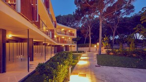 Un edificio moderno con varios balcones y un camino bien iluminado.