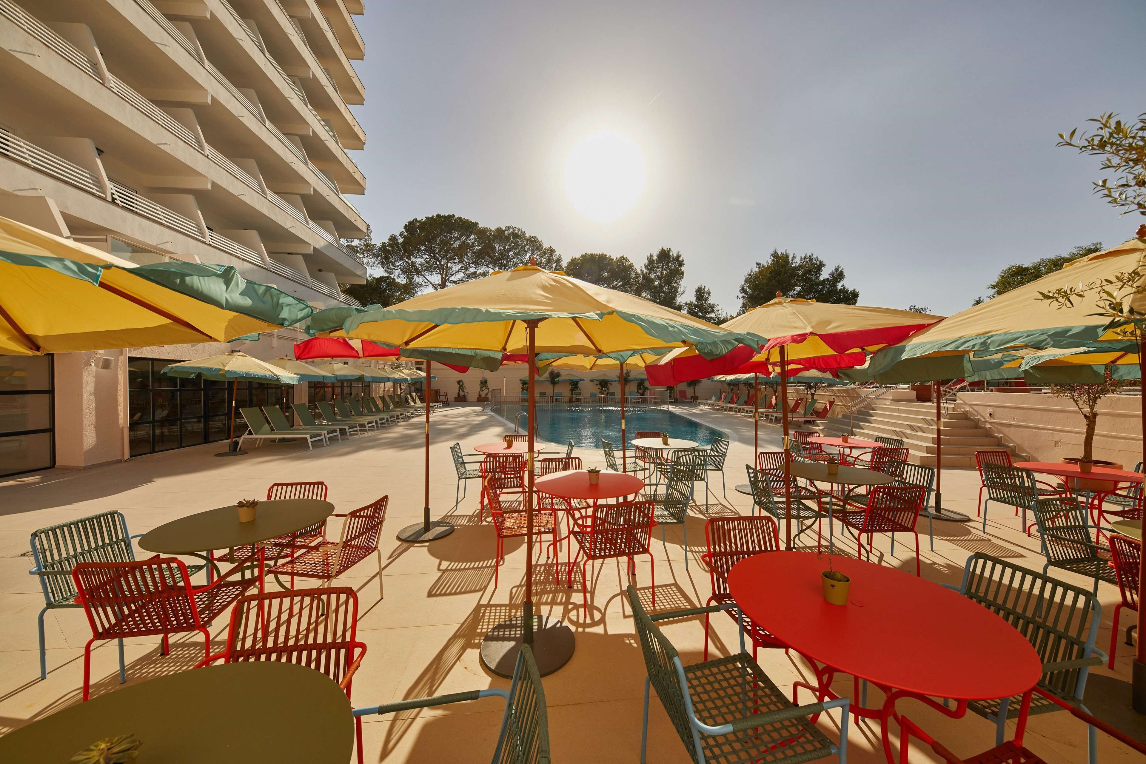 A poolside area with outdoor seating and umbrellas.