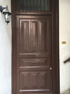 A brown wooden door with a metal handle and a keyhole. - La Querencia (Palermo)