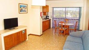 Ein kompakter Wohnbereich mit Küchenzeile, Essplatz und einer Couch.