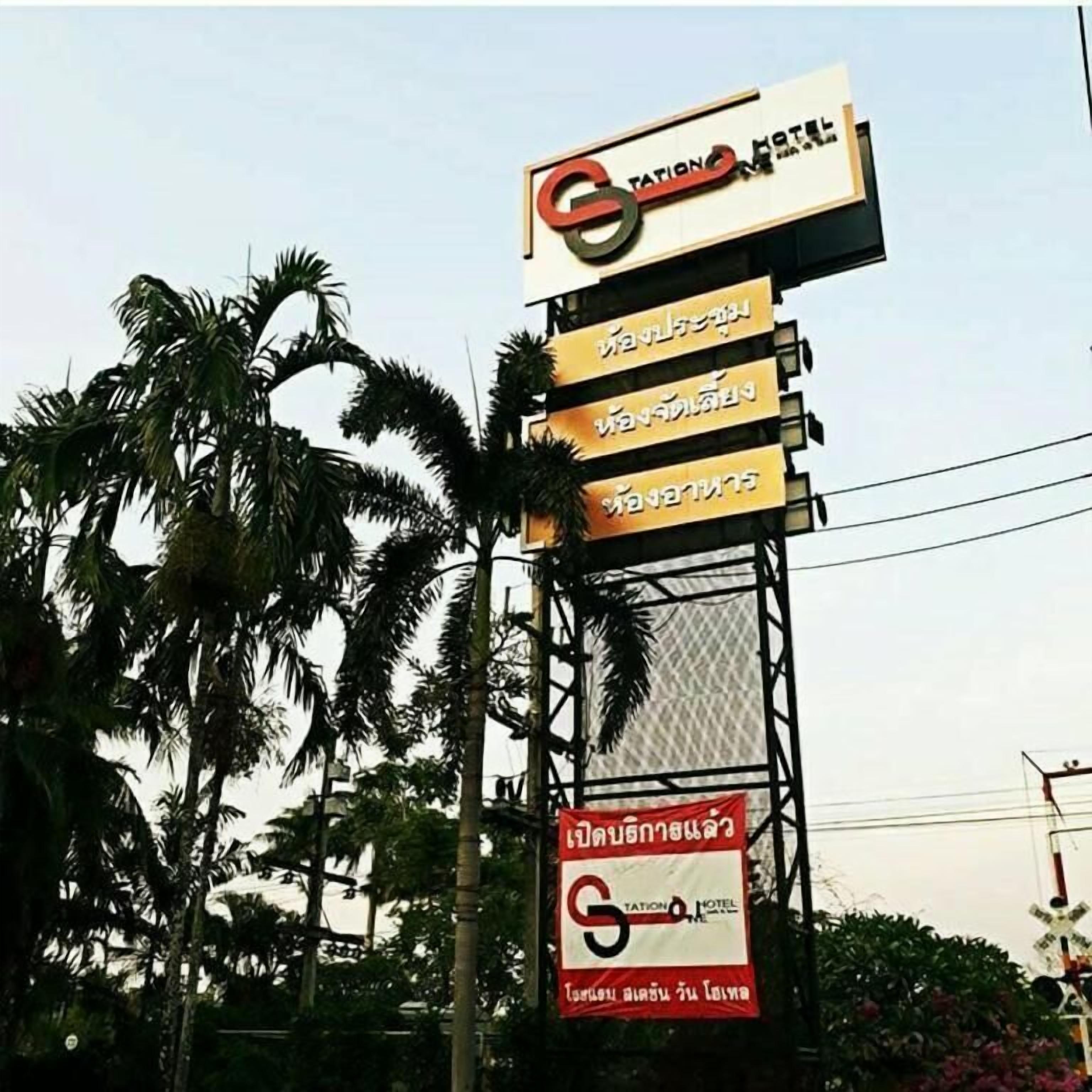 A hotel sign with multiple languages and a prominent logo.