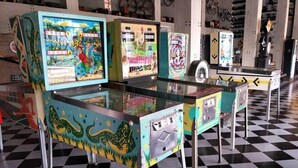 Eine Retro-Spielhalle mit bunten Spielautomaten und Schachbrettfußboden.