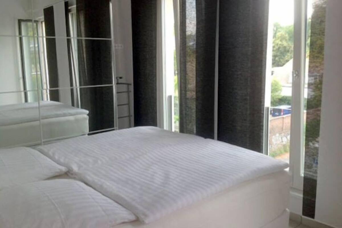 Un dormitorio moderno con una cama grande, un armario y una ventana con vistas al exterior.