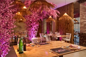 A restaurant with wooden tables, chairs, and hanging lamps. - ROBINSON NAM HOI AN (Da Nang)