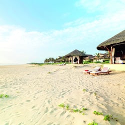 Na praia, areia branca, guarda-sóis, toalhas de praia