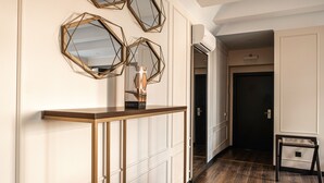 A hallway with a wooden console table, geometric mirrors, and a small side table. - De Paris Apartments (Kyiv)