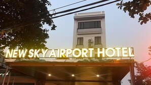 De ingang van het New Sky Airport Hotel met een duidelijk bord boven de ingang.