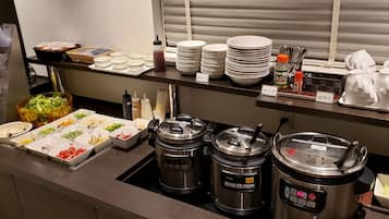 Montaje de bufé con diferentes alimentos y salsas, incluyendo ensaladas, aderezos y una variedad de fuentes calientes.