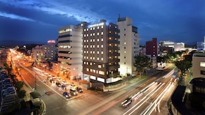 A multi-story hotel with a modern design, featuring a prominent entrance and multiple balconies. - Sunrise Inn Iwaki (Iwaki)