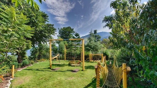 Une aire de jeux avec des balançoires et un pont de corde.