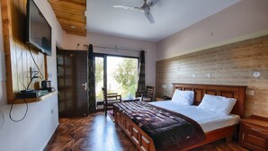 Une chambre avec un lit en bois, un ventilateur de plafond et une vue sur l’extérieur.
