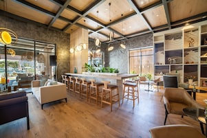 A modern interior with a bar area, seating, and a view of the outdoors.