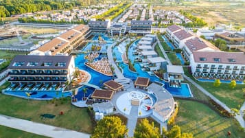 An aerial view of a resort with multiple swimming pools, a central plaza, and resort buildings.