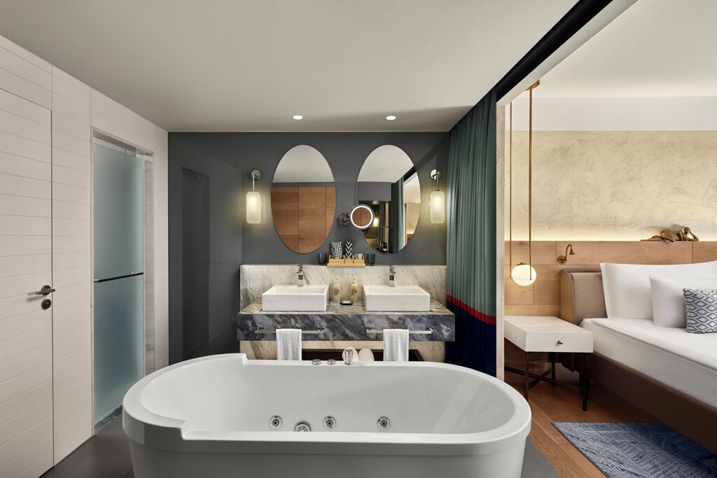 A modern bathroom with a freestanding bathtub, dual sinks, and a vanity with a mirror.