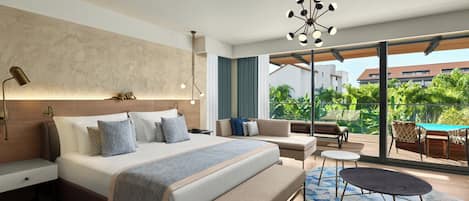 Una habitación de hotel moderna con una cama grande, un sofá, una mesita y un banco. Cuenta con un balcón con una mesa y sillas.