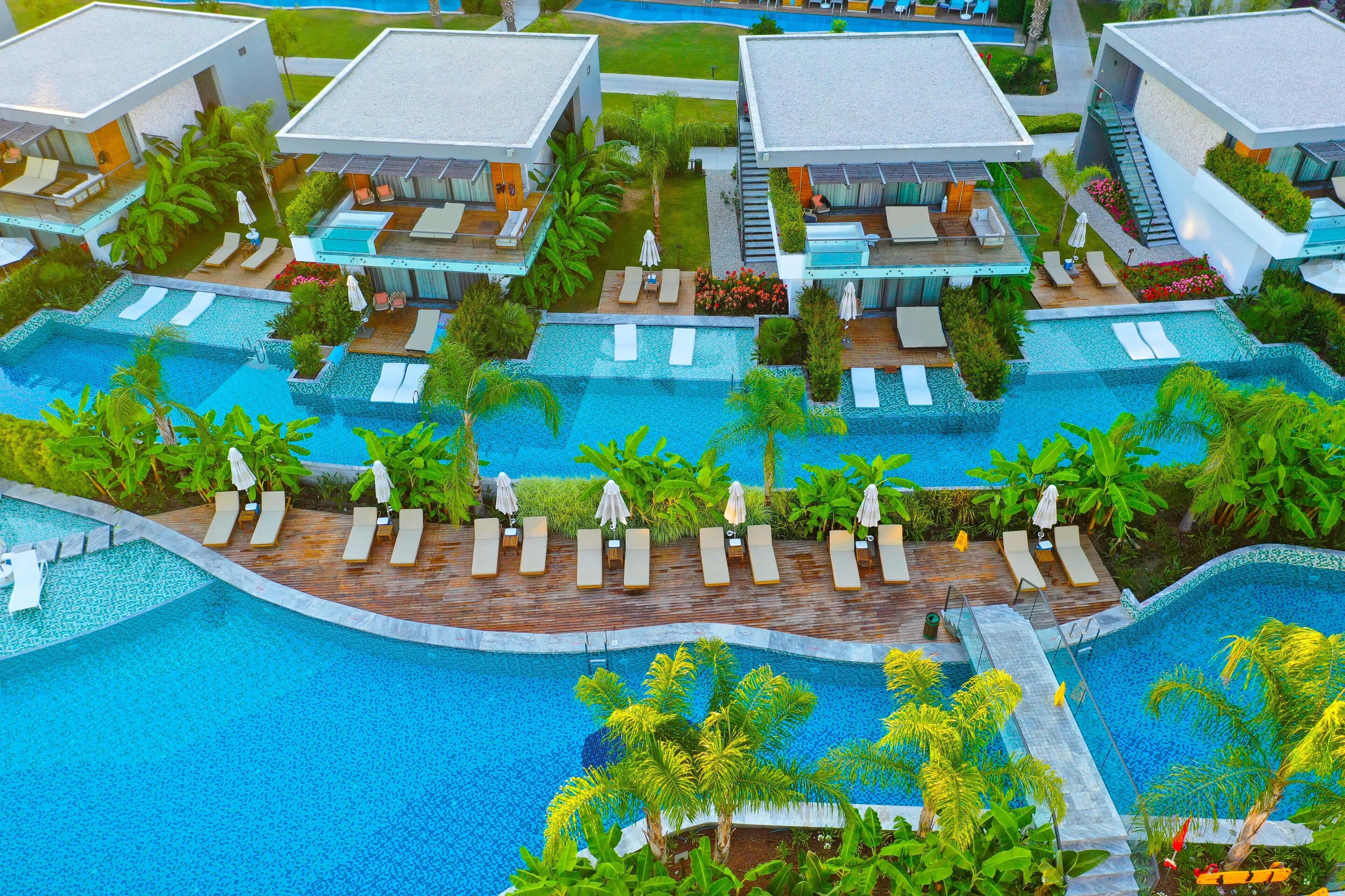 Un resort con diverse piscine, aree relax e architettura moderna.