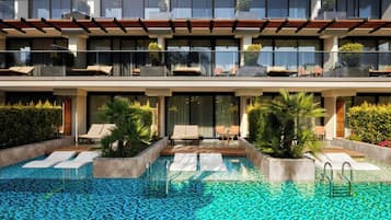 Un hôtel moderne doté d’une piscine sur le toit, de chaises longues et offrant une vue dégagée sur la piscine.