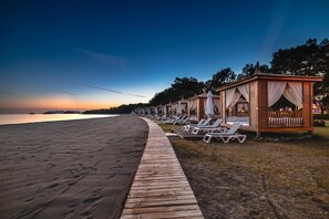 En la playa, camastros, sombrillas y toallas de playa 