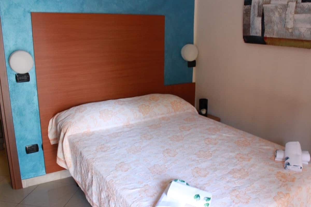 Ein ordentlich bezogenes Bett mit Blumenmuster, einem Holzkopfbrett und Nachttischlampen.